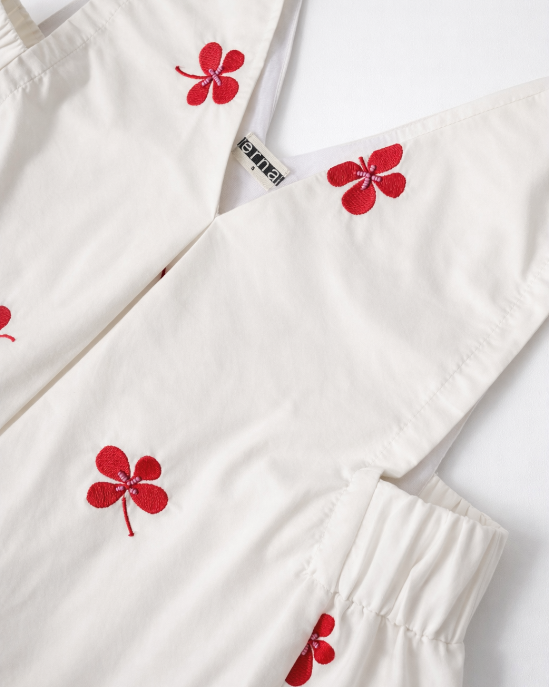 Close-up of clover embroidery and hand beadwork on Roma cotton poplin midi dress by Erna.
